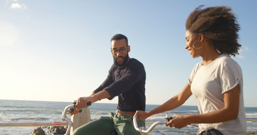 Romantic diverse couple riding bikes and smiling on sunny beach, copy space - Free Images, Stock Photos and Pictures on Pikwizard.com