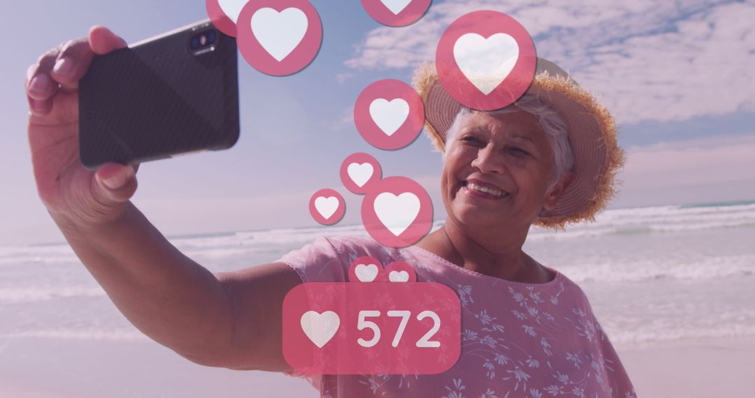 Senior Woman Taking Selfie at Beach with Social Media Love Icons - Free Images, Stock Photos and Pictures on Pikwizard.com