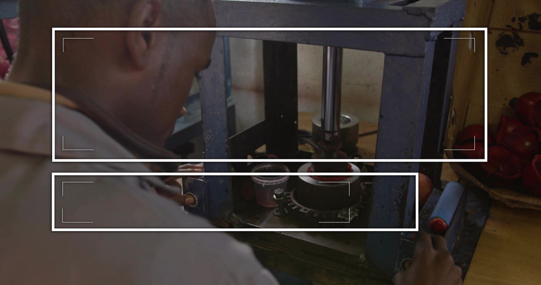 Technician Operating Hydraulic Fruit Press in Workshop