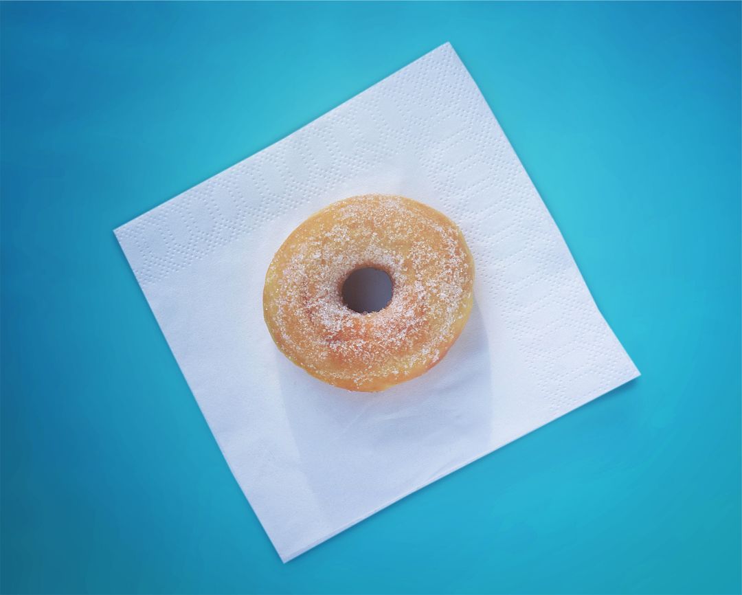 Sugary Doughnut on a White Napkin with Blue Backdrop