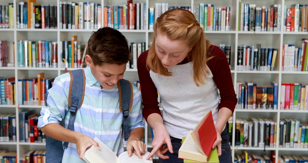 Two Students Studying Together in Library with Bookshelves in Background - Free Images, Stock Photos and Pictures on Pikwizard.com