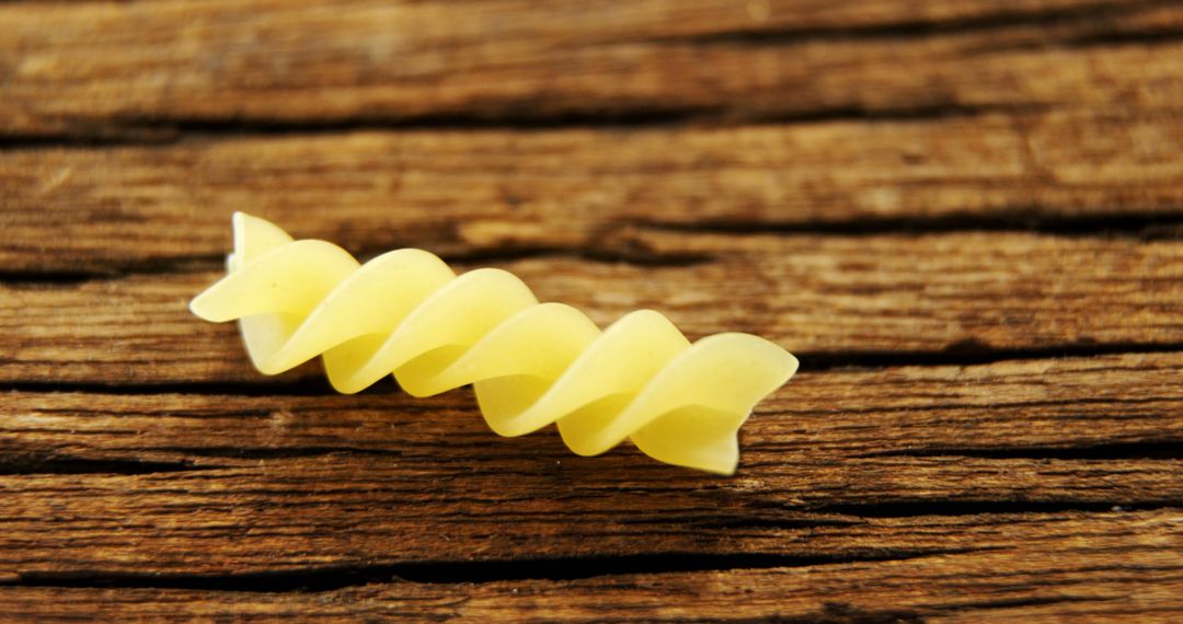 Closeup of Fusilli Pasta Single Piece on Rustic Wood Surface - Free Images, Stock Photos and Pictures on Pikwizard.com