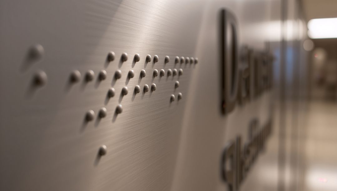 Braille Tactile Sign on Modern Corridor Wall with Embossed Text
