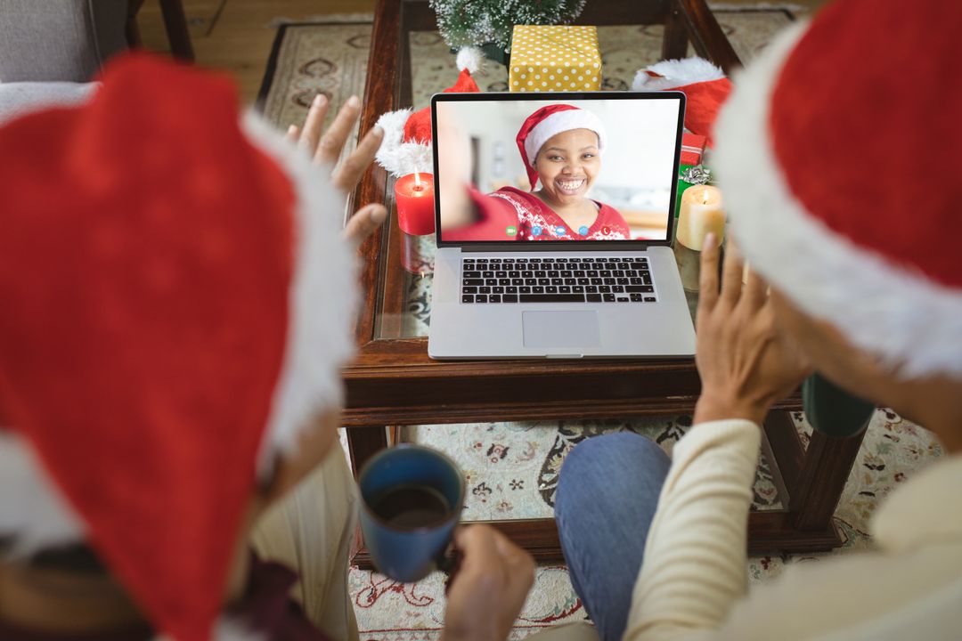 Diverse couple with santa hats having video call with happy african american woman - Free Images, Stock Photos and Pictures on Pikwizard.com