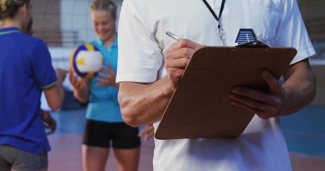 Volleyball Coach Planning Strategy with Team in Indoor Gym