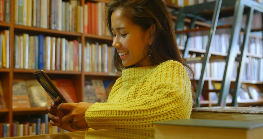 Smiling Woman Using Tablet in Library - Free Images, Stock Photos and Pictures on Pikwizard.com