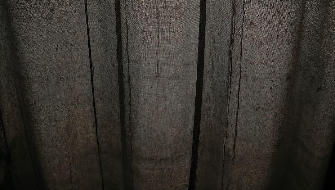 Dark Linen Curtain Closeup Showing Vertical Seams, Pleats and Woven Texture with Backlight