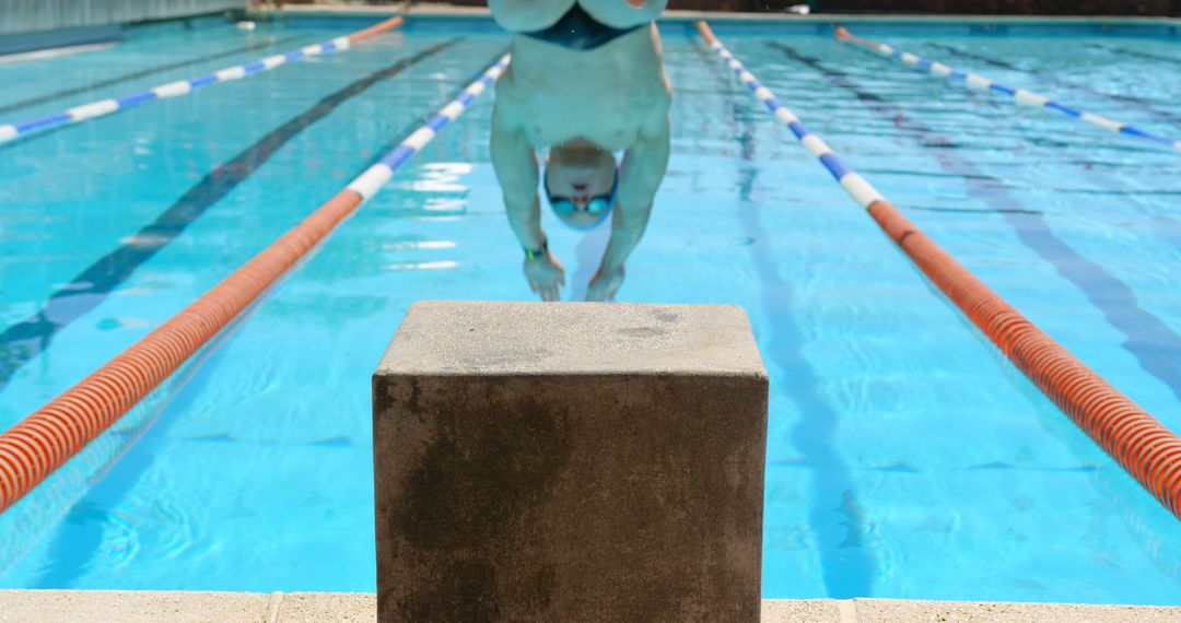 Swimmer Diving into Pool from Starting Block - Free Images, Stock Photos and Pictures on Pikwizard.com