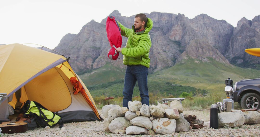 Man Packing Sleeping Bag During Camping Trip in Mountains - Free Images, Stock Photos and Pictures on Pikwizard.com