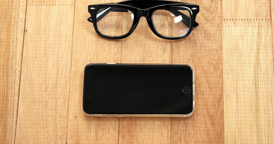 Black Smartphone and Glasses on Wooden Surface - Free Images, Stock Photos and Pictures on Pikwizard.com