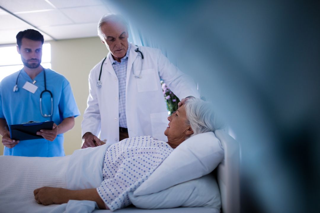 Doctors comforting senior patient on hospital bed - Free Images, Stock Photos and Pictures on Pikwizard.com