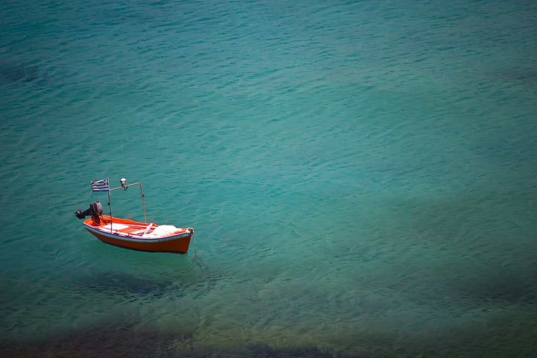 Lonely Red Boat Floating on Calm Turquoise Sea - Free Images, Stock Photos and Pictures on Pikwizard.com