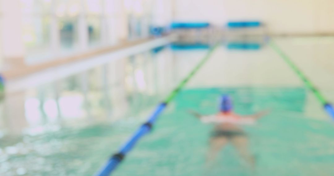 Blurry Indoor Pool with Swimmer Floating