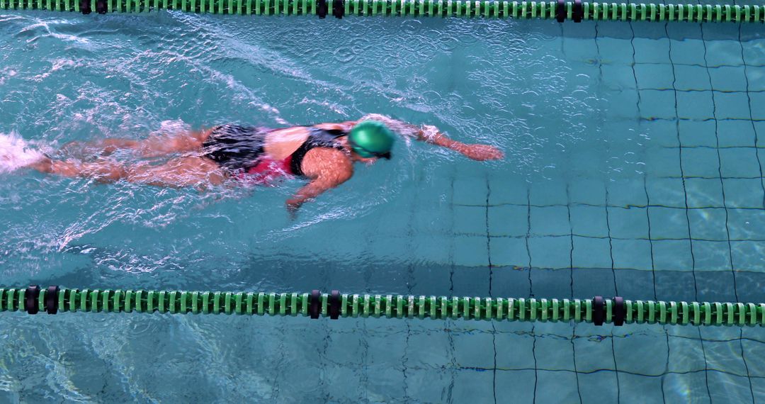 Young Woman Swimming Freestyle in Pool with Green Swim Cap - Free Images, Stock Photos and Pictures on Pikwizard.com