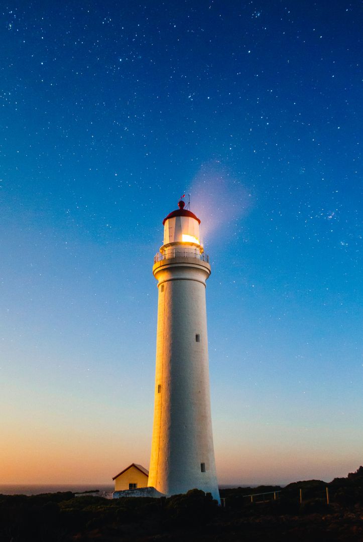 Lighted Lighthouse at Dusk with Starry Sky Background - Free Images, Stock Photos and Pictures on Pikwizard.com