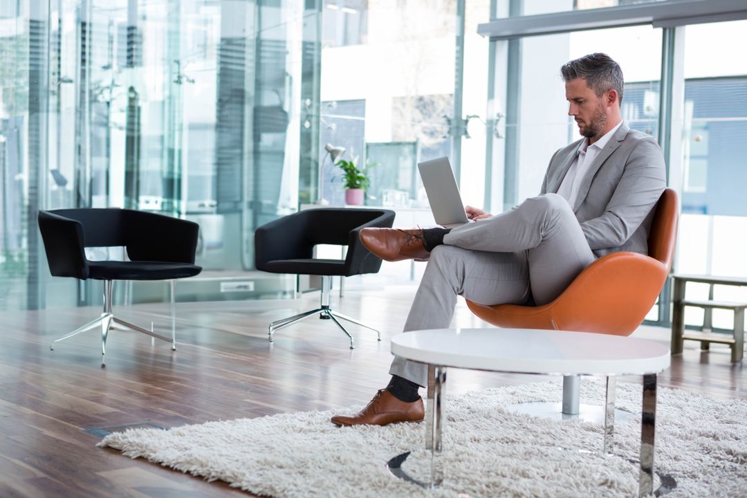 Business Executive in Modern Lounge Working on Laptop
