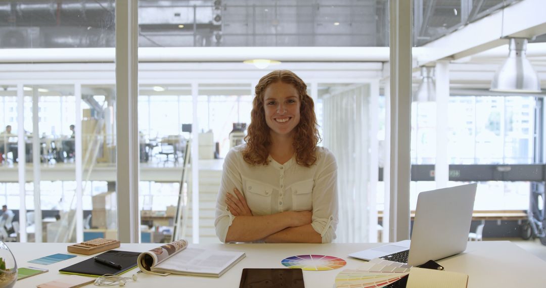 Confident Female Designer Smiling at Desk in Modern Office - Free Images, Stock Photos and Pictures on Pikwizard.com