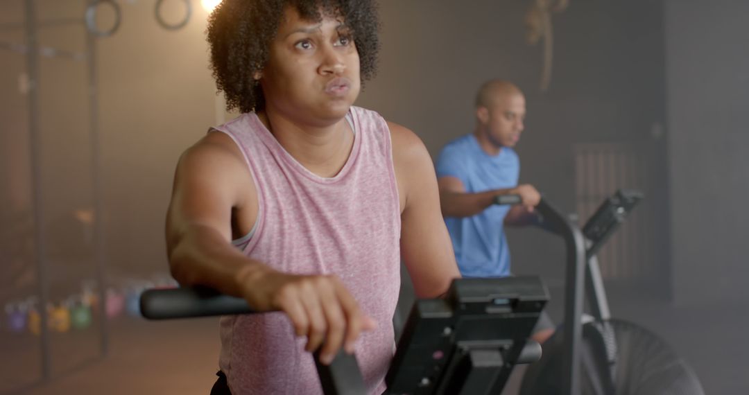 Determined people working out on exercise bikes in a gym - Free Images, Stock Photos and Pictures on Pikwizard.com