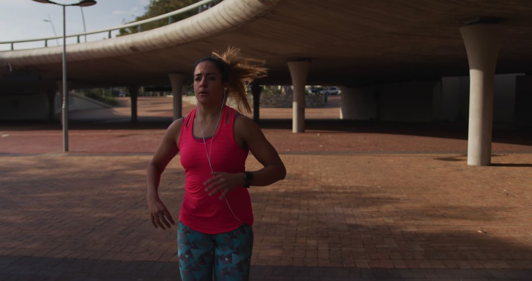 Woman Jogging Under Urban Overpass on Sunny Day - Free Images, Stock Photos and Pictures on Pikwizard.com