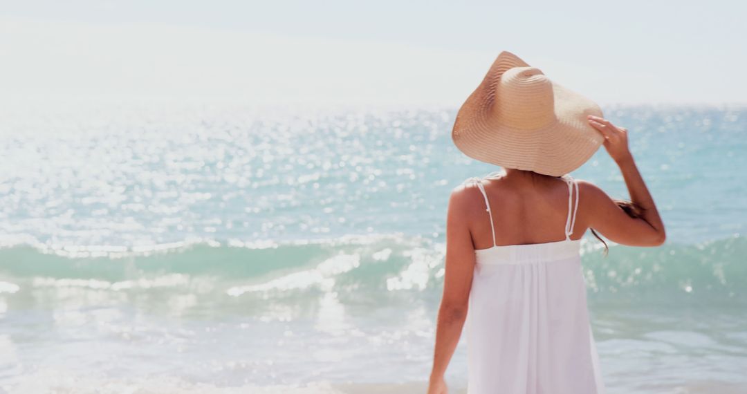 Woman Relaxing at Beach in Sun Hat and White Dress - Free Images, Stock Photos and Pictures on Pikwizard.com