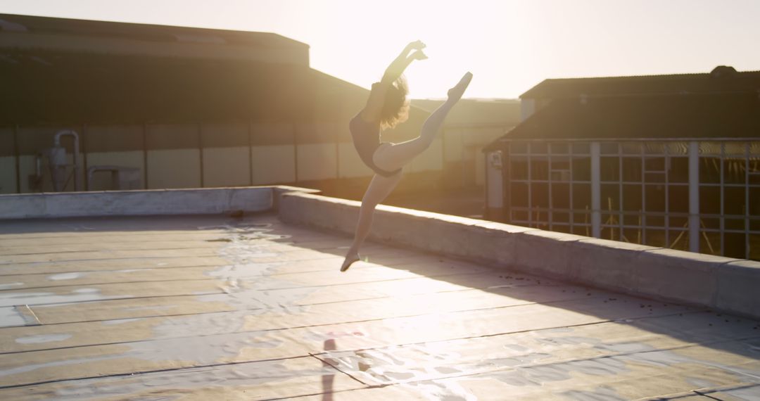 Ballet Dancer Performing Jump on Rooftop at Sunset - Free Images, Stock Photos and Pictures on Pikwizard.com