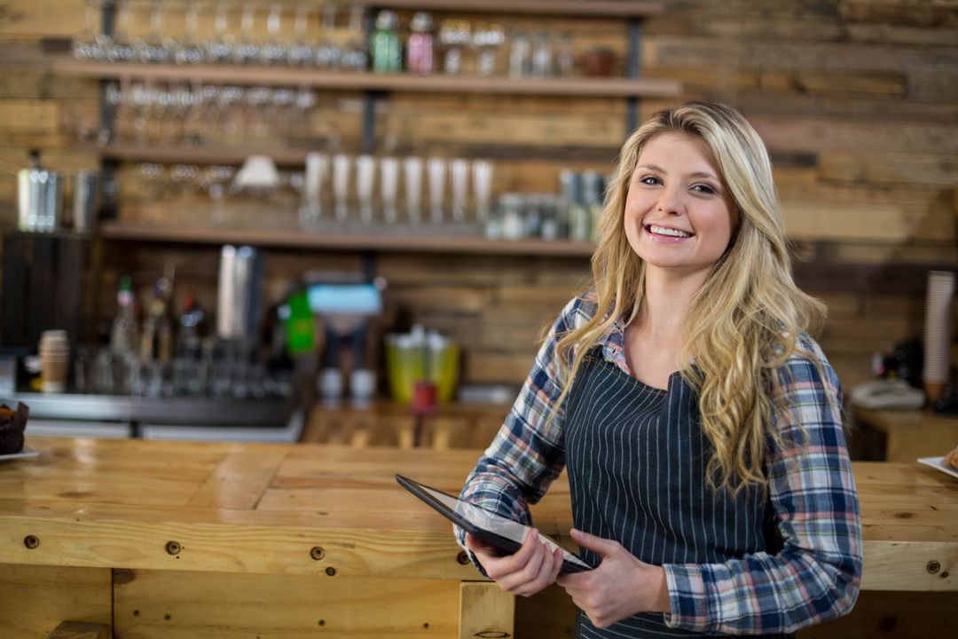 Friendly Barista Holding Tablet in Rustic Cafe