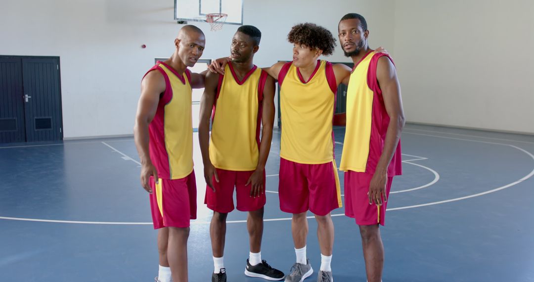 Diverse Basketball Team Strategizing in Gymnasium