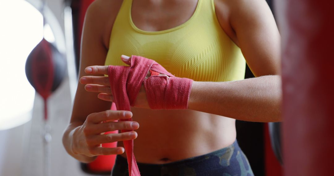 Female Boxer Wrapping Hands with Red Bandages in Gym - Free Images, Stock Photos and Pictures on Pikwizard.com