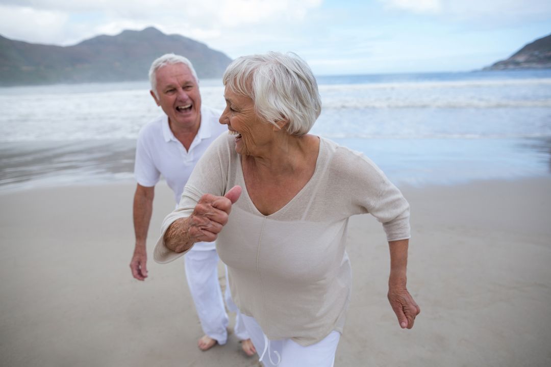 Joyful Senior Couple Enjoying Beach Time - Free Images, Stock Photos and Pictures on Pikwizard.com
