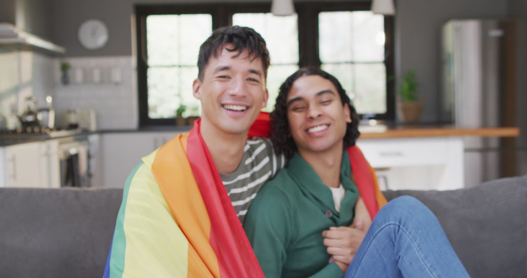 Happy LGBTQ+ Couple Celebrating with Rainbow Flag in Modern Living Room - Free Images, Stock Photos and Pictures on Pikwizard.com