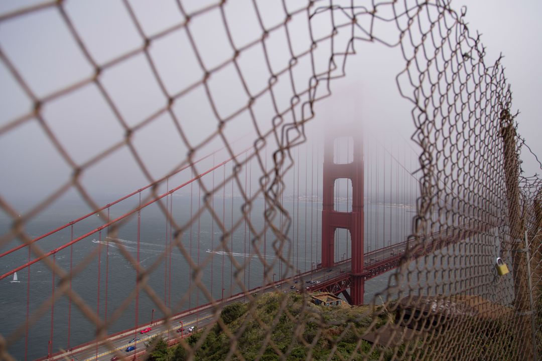 Golden Gate Bridge Viewed Through Rusty Fence on Foggy Day - Free Images, Stock Photos and Pictures on Pikwizard.com