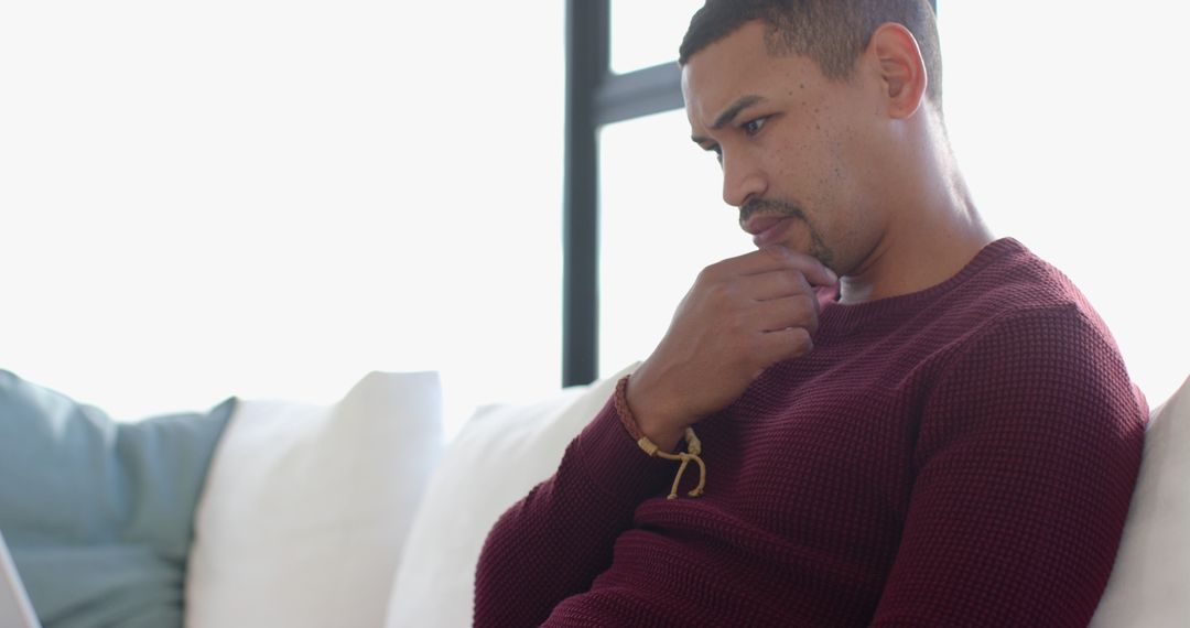 Man in Deep Thought at Home Relaxing on Modern Sofa