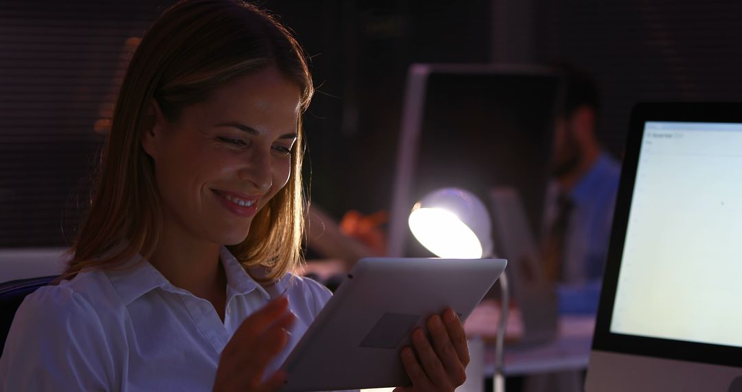 Woman Using Digital Tablet in Office at Night - Free Images, Stock Photos and Pictures on Pikwizard.com