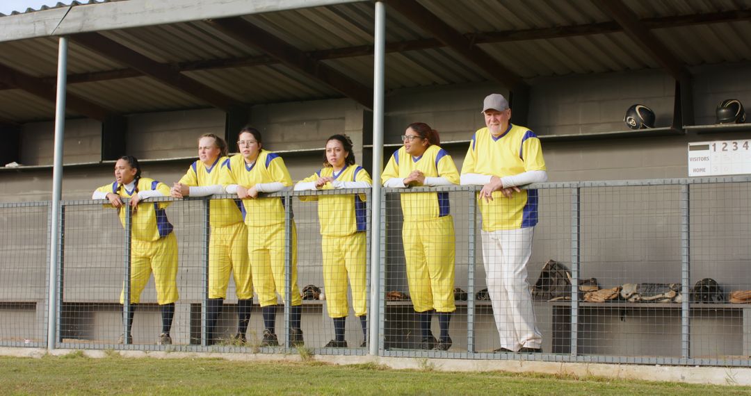 Diverse Softball Team Observing Match from Dugout