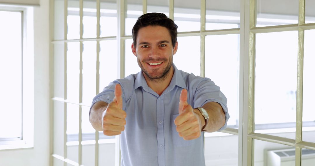 Cheerful businessman showing thumbs up in the office - Free Images, Stock Photos and Pictures on Pikwizard.com