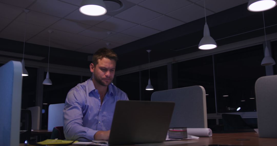 Man Working Late on Laptop in Modern Office at Night - Free Images, Stock Photos and Pictures on Pikwizard.com