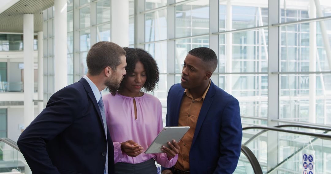 Diverse Business Team Discussing Digital Strategy in Office Lobby