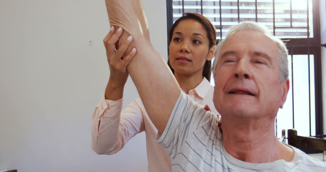 Physical Therapist Assisting Elderly Man with Arm Stretching Exercise - Free Images, Stock Photos and Pictures on Pikwizard.com