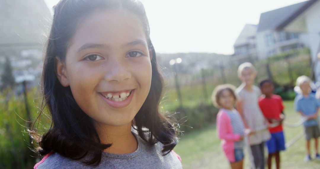 Smiling Girl Outdoors with Friends in Background - Free Images, Stock Photos and Pictures on Pikwizard.com