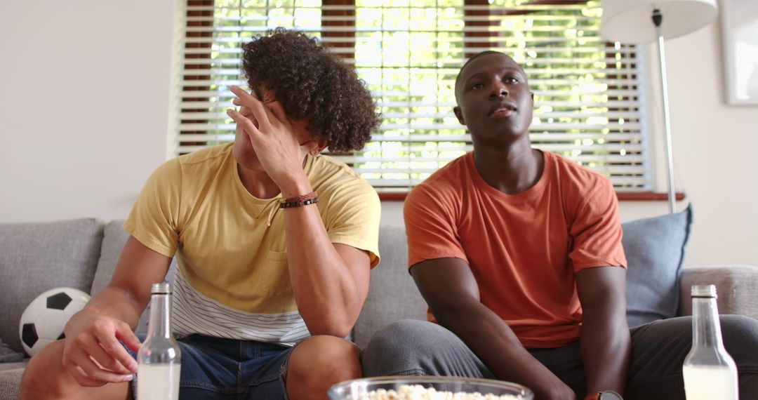 Diverse Friends Enjoying Soccer Game at Home with Snacks