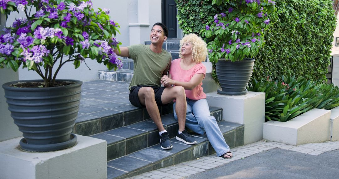 Happy Couple Sitting on Doorstep of New Home