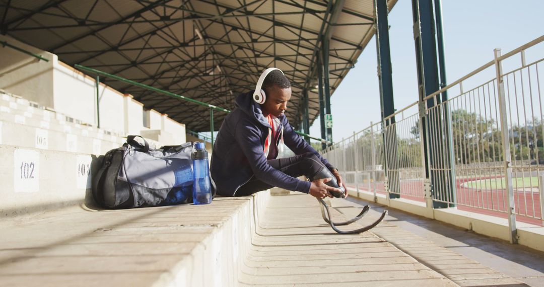 Male Athlete Preparing for Training on Stadium Bleachers - Free Images, Stock Photos and Pictures on Pikwizard.com