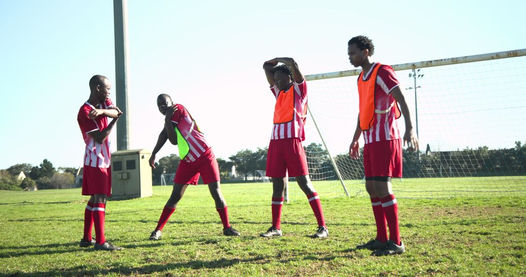 Young Athletes Preparing on Soccer Field in Vibrant Striped Kits
