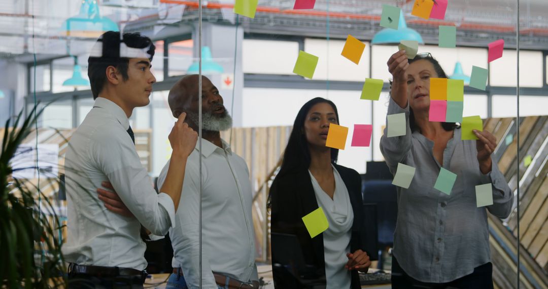 Diverse Team Collaborating with Sticky Notes on Glass Wall - Free Images, Stock Photos and Pictures on Pikwizard.com