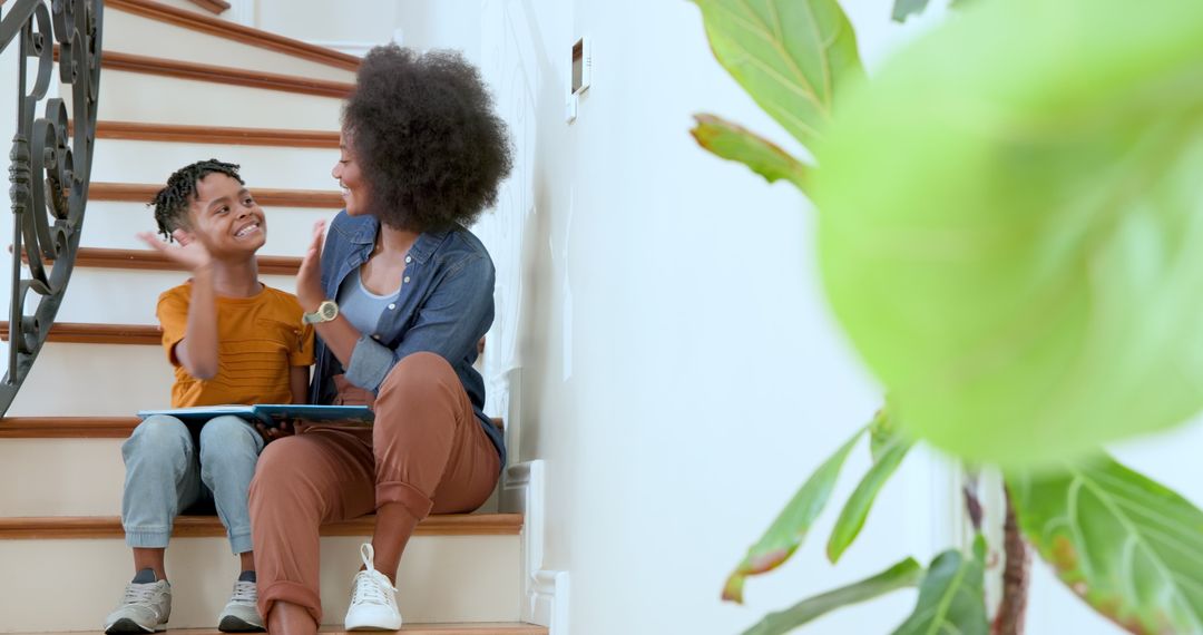 Mother and Son Sharing Story Time on Stairs with Book