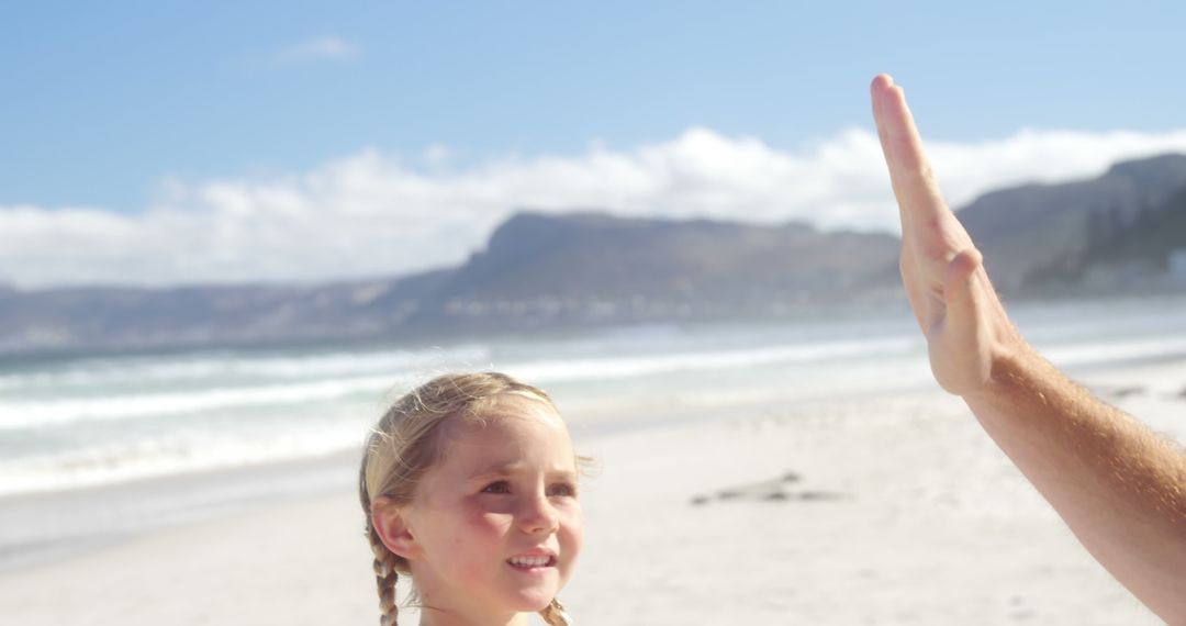 Smiling Girl Receiving High Five on Sunny Beach - Free Images, Stock Photos and Pictures on Pikwizard.com