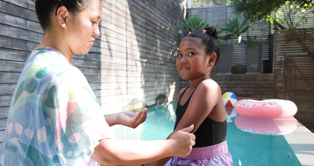 Mother and Daughter Bonding at Poolside with Donut Float and Beach Ball