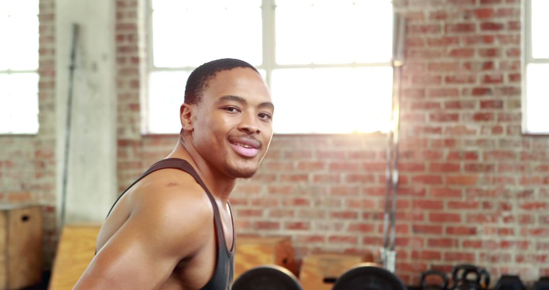 Athletic Man Smiling in Gym with Sunlight - Free Images, Stock Photos and Pictures on Pikwizard.com