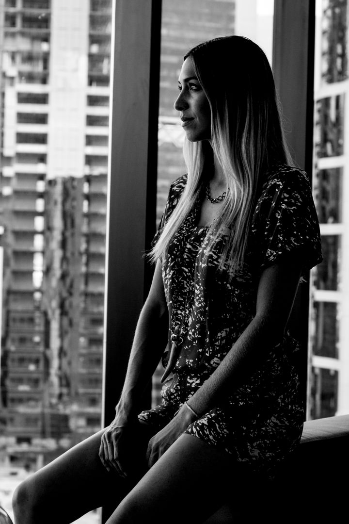 Woman Sitting by Window Overlooking Urban Cityscape - Free Images, Stock Photos and Pictures on Pikwizard.com