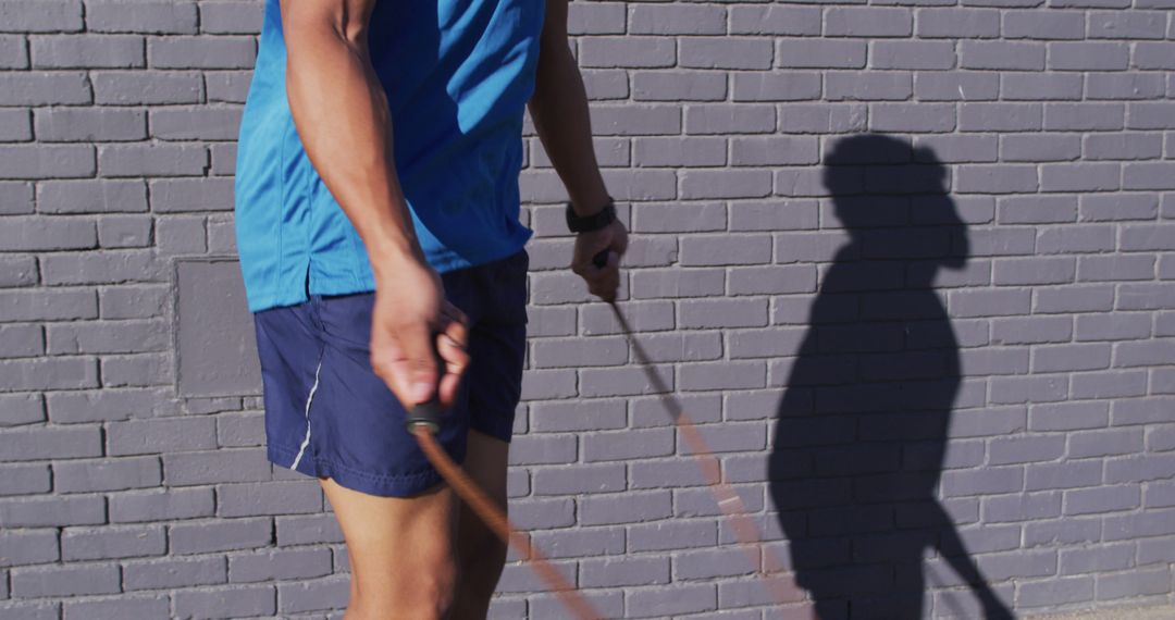 Man Jumping Rope for Outdoor Fitness Exercise by Brick Wall - Free Images, Stock Photos and Pictures on Pikwizard.com